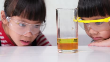 los niños están aprendiendo y haciendo experimentos científicos en el aula. dos hermanas pequeñas jugando a experimentos científicos para la escuela en casa. experimentos científicos fáciles y divertidos para los niños en casa.