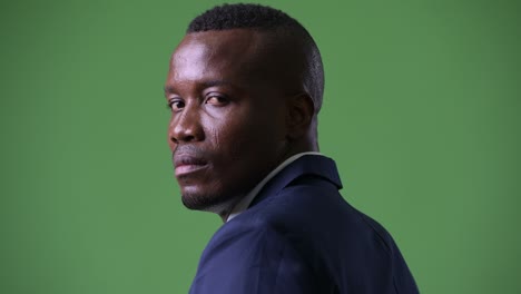 face of young african businessman looking back