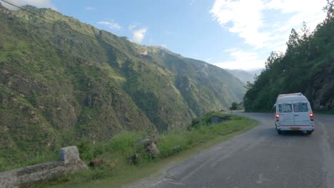 force traveler riding through kinnaur shimla road carved through mountain and steep rocky cliff in the himalaya