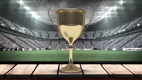 Animation-of-gold-cup-in-rugby-field-with-camera-flashes-in-sports-stadium