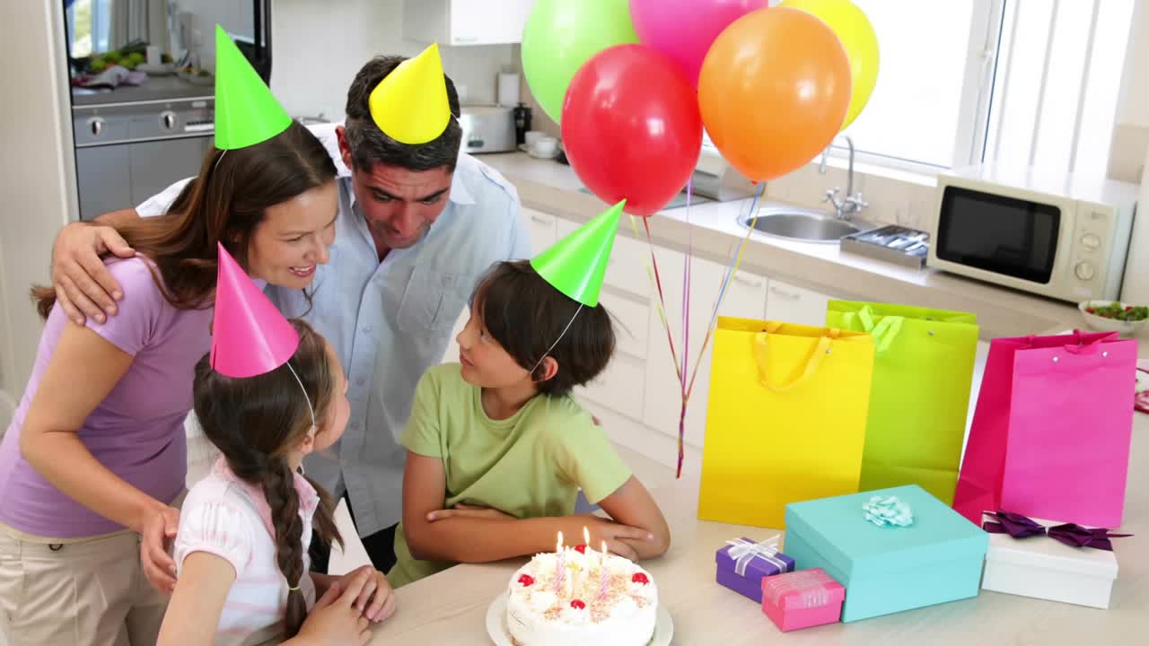 Family gathering around cake, confetti releasing after gathering, boy making birthday wish