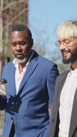 two businessmen chatting walking along the city