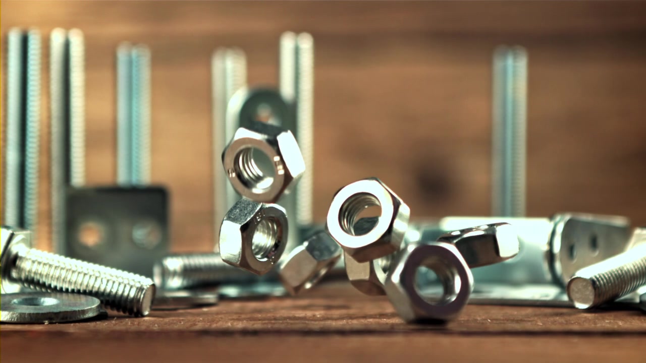 Metal Nuts Falling in Slow Motion onto a Wooden Surface