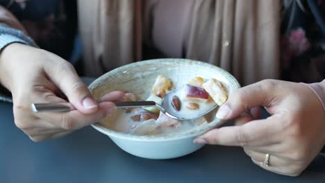 woman enjoying a delicious fruit and nut dessert