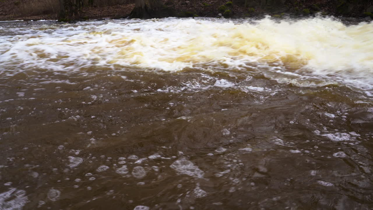 fuerte flujo de las aguas de un manantial fangoso en el río del campo, inclinación hacia arriba