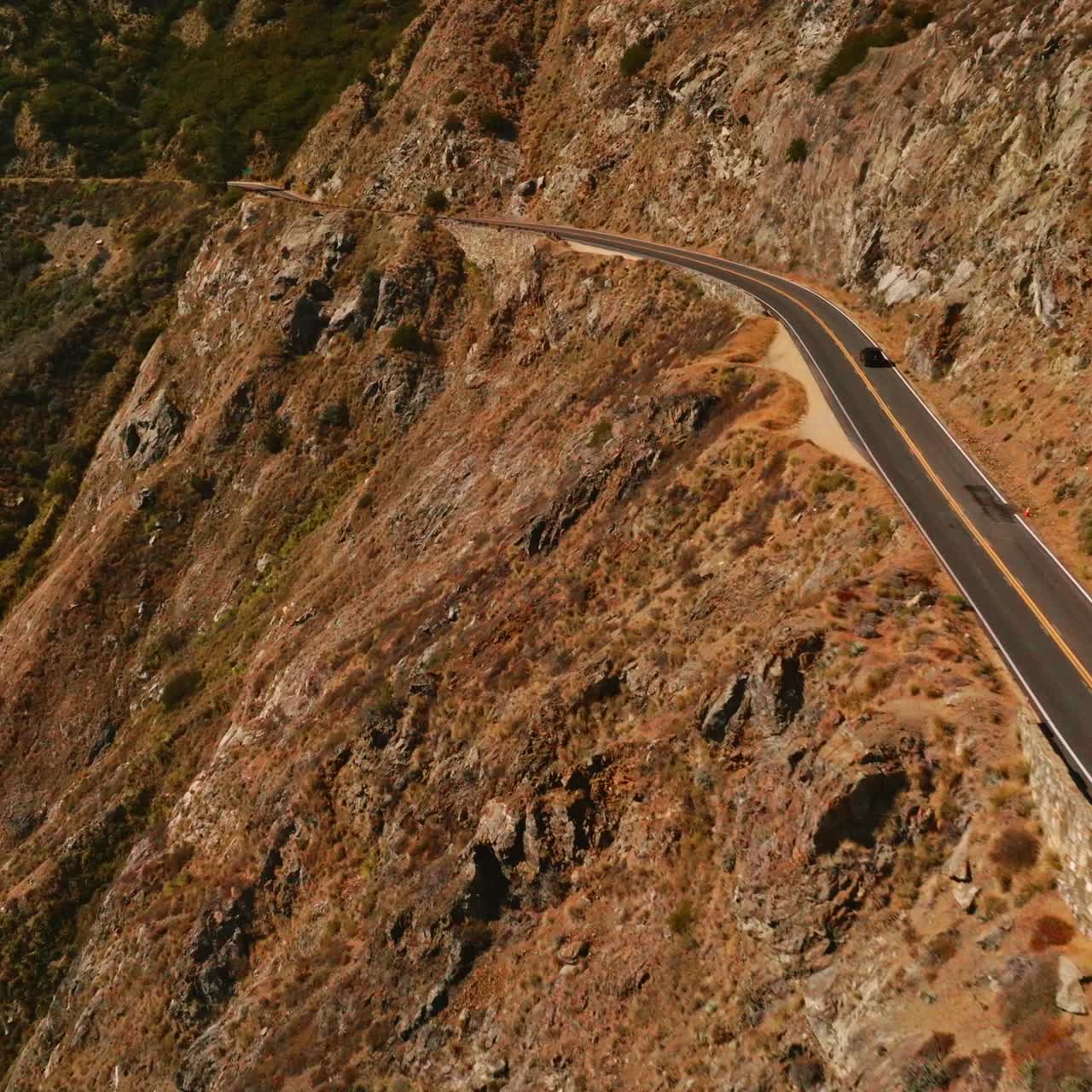 Flying along the road passing through the mountains. Huge rocks of Big Sur Morro Bay in California, USA