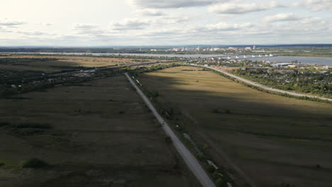 aerial view of a countryside road and highway crossing near a river and city