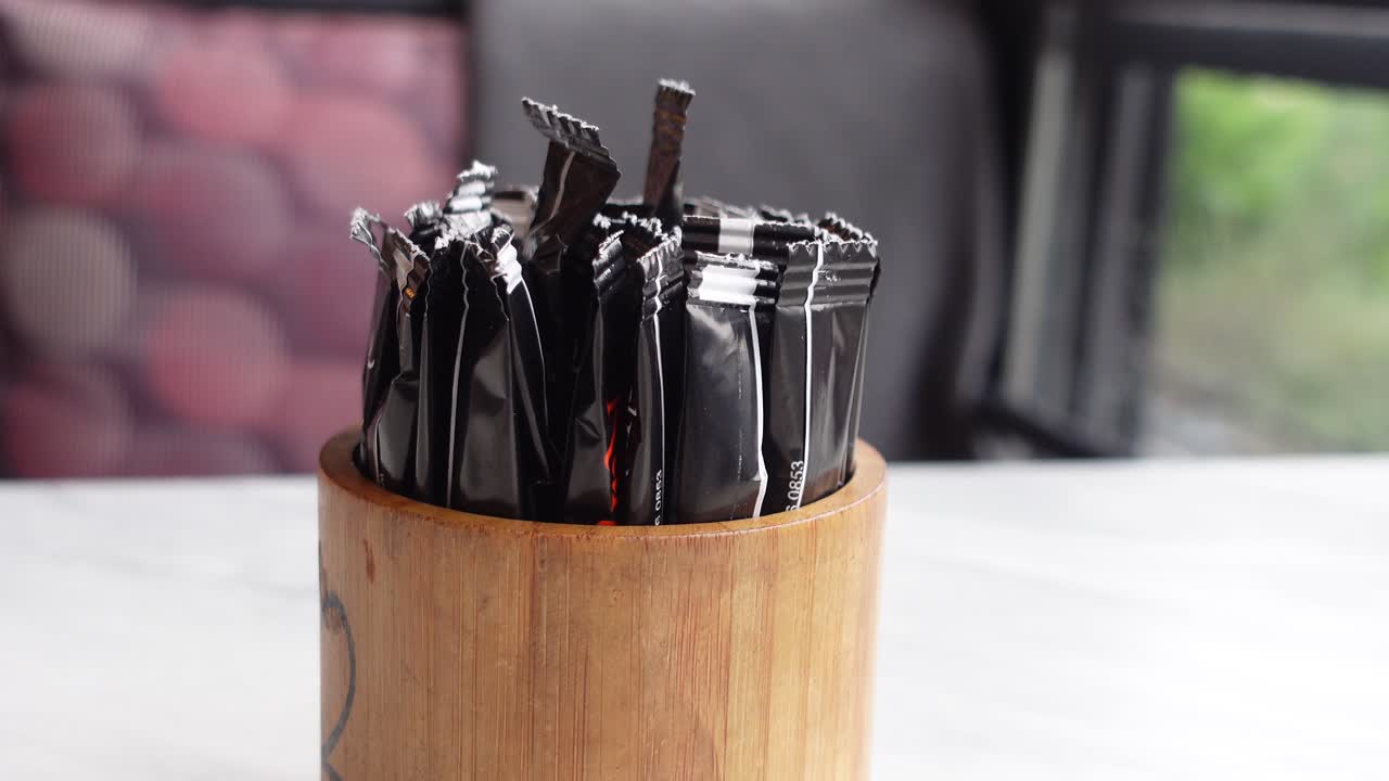 primer plano de paquetes de condimentos en un soporte de madera en una mesa