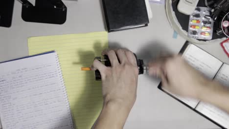 Man-Hands,-Using-Manual-Old-Fashioned-Pencil-Sharpener-on-Table
