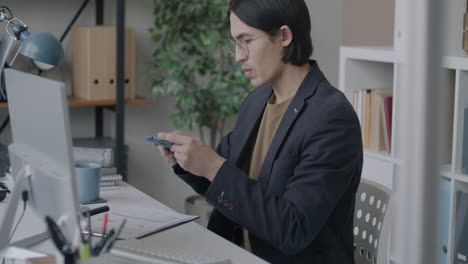 hombre usando teléfono inteligente en la oficina