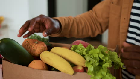 man receiving box of vegetables