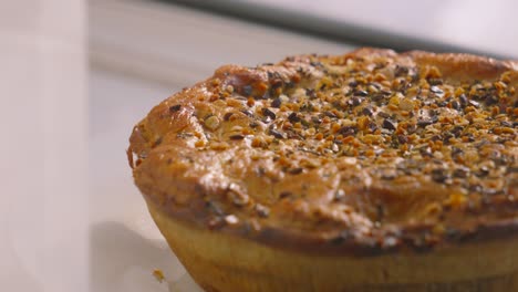 pan across whole chicken and mushroom pie with various seeds on top ready to cut portions and serve for dinner. british cuisine slow motion food footage