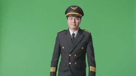 asian man pilot walking and smiling in the green screen background studio