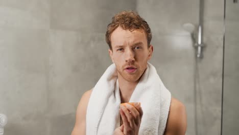 Athletic-man-in-the-bathroom-applies-wax-to-hair-for-styling