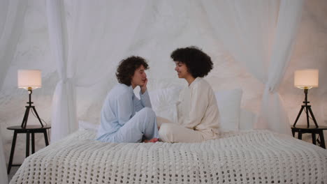 Happy-couple-talking-on-bed