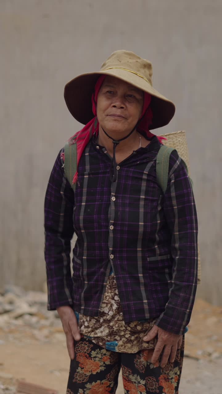 Older woman in hat and plaid shirt with basket on back