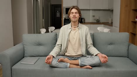 Young-man-starts-to-meditate-in-his-living-room-on-the-couch