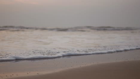 playa en un día nublado con el océano es tranquilo y el cielo es un hermoso tono de rosa