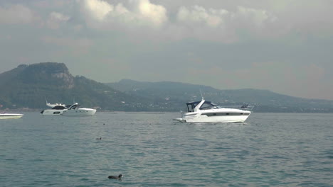 toma en cámara lenta de yates atracados en un paisaje escénico en el lago de garda, italia