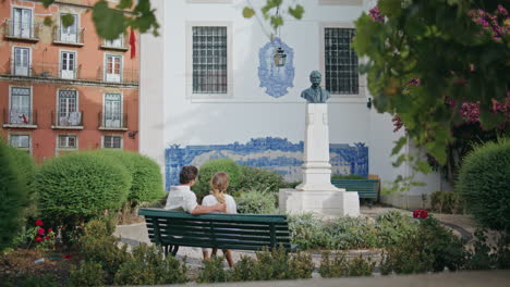 una pareja de amor sentada en un banco hablando en un parque urbano. un hombre abrazando a su novia en una cita.