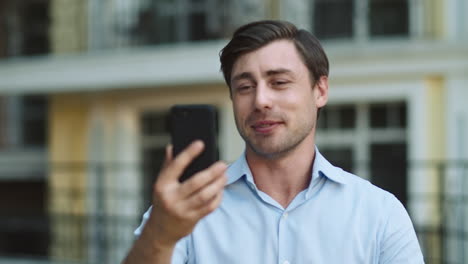 closeup businessman using phone for video call. man having video chat at street