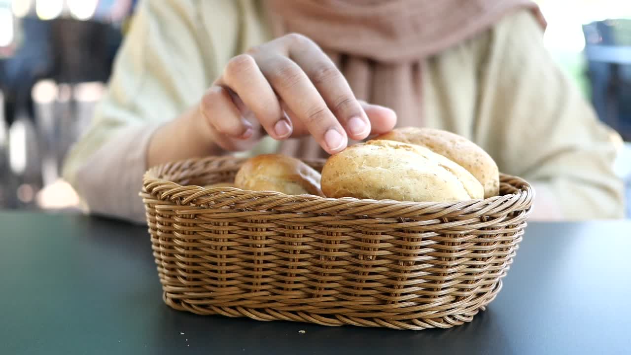 Woman Eating Bread from a Basket