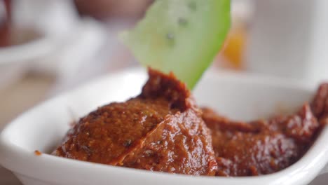 close-up of a spicy red dip or spread in a white bowl