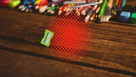animación de afilador de lápices y borrador rebotando en puntos rojos sobre el escritorio con lápices