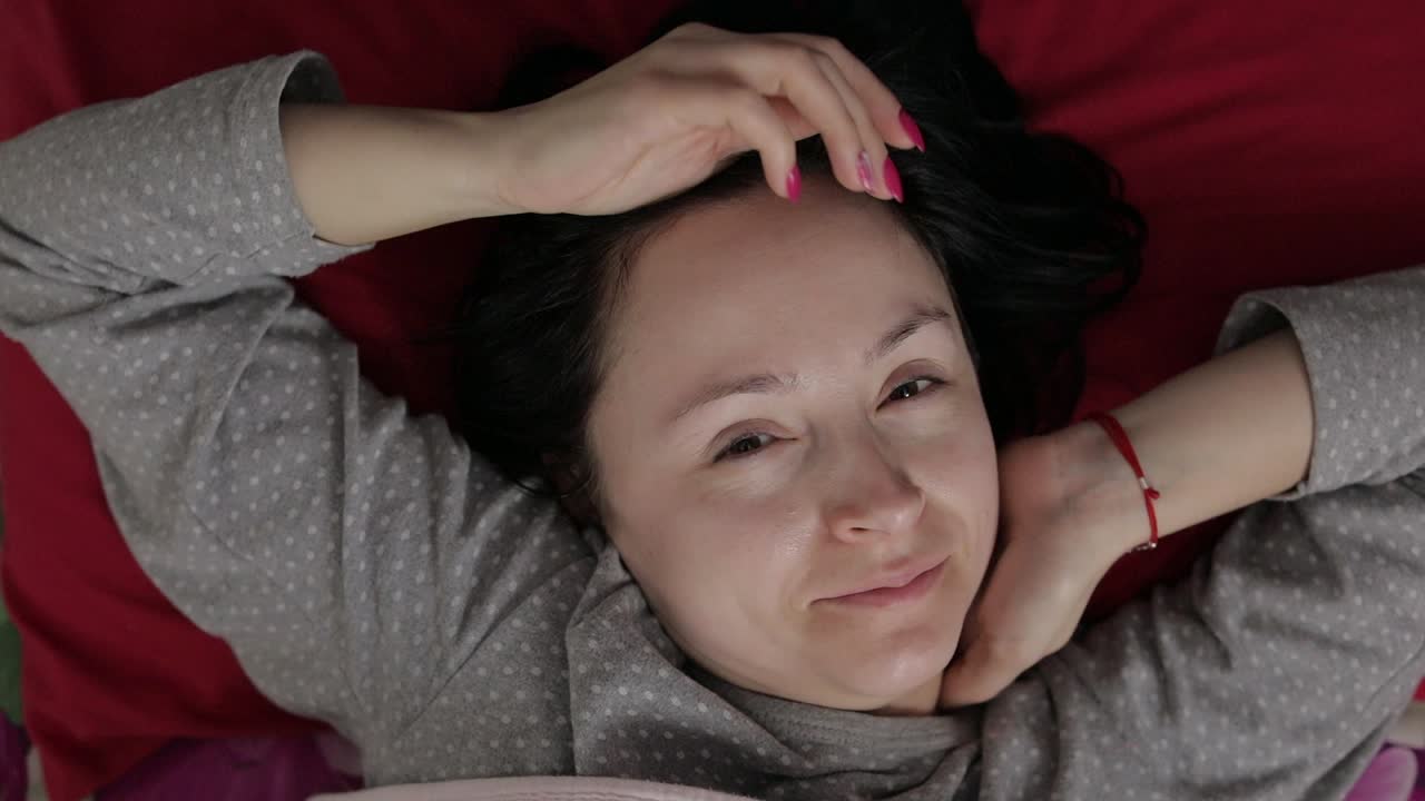 mujer joven somnolienta no quiere despertar por la mañana. vista superior