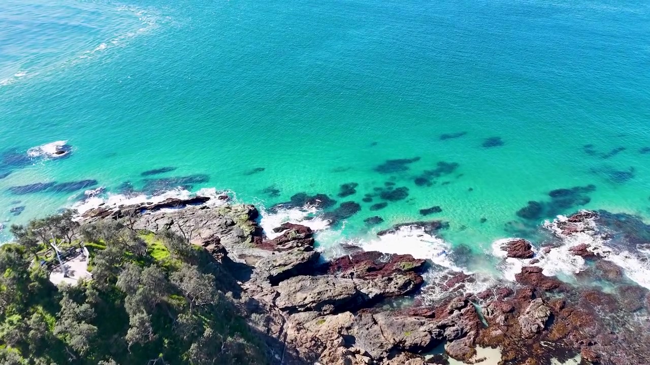 Vista aerea delle onde turchesi dell'oceano che si schiantano sulla costa rocciosa