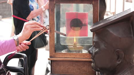 gente encendiendo incienso en un santuario