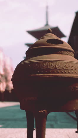 close-up of an incense burner in front of a japanese temple