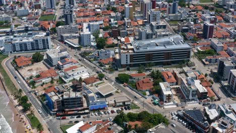 Dolly-out-tilt-up-aerial-shot-of-the-tropical-capital-of-Joao-Pessoa-from-intermares-beach-in-Cabedelo,-Brazil-with-skyscrapers-along-the-coastline-in-the-state-of-Paraiba-on-a-warm-sunny-summer-day