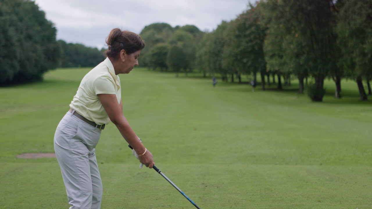 Woman golfing on a green field