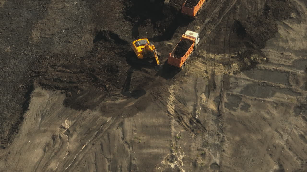 excavadoras y camiones de descarga que trabajan en un sitio de construcción