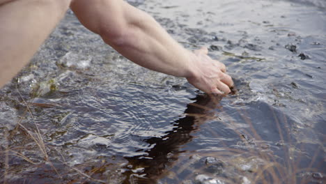 zeitlupe - eisbadende hände schaufeln eis weg, um das wasser zu reinigen