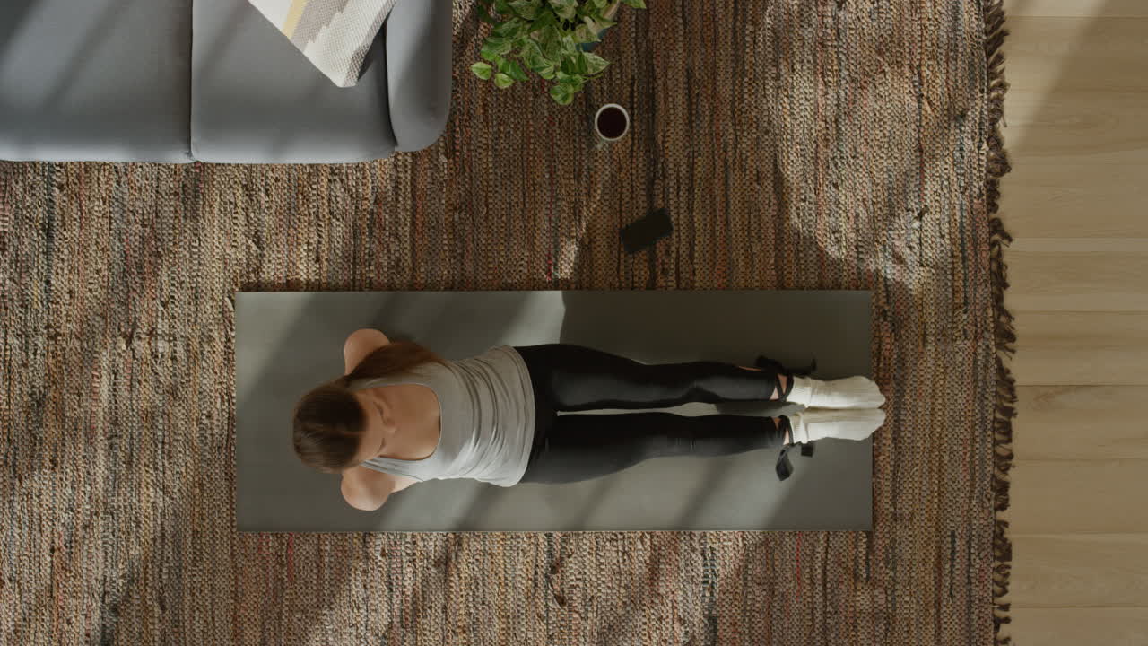vista superior de una mujer de yoga practicando una pose de tabla hacia arriba ejerciendo un estilo de vida saludable en casa sobre una colchoneta de ejercicios disfrutando de la meditación de atención plena.