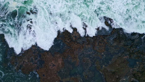 drone view stormy ocean surf crashing volcanic seaside. foamy sea waves coast