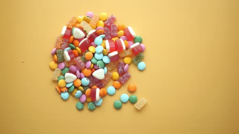 colorful assortment of candies on yellow background