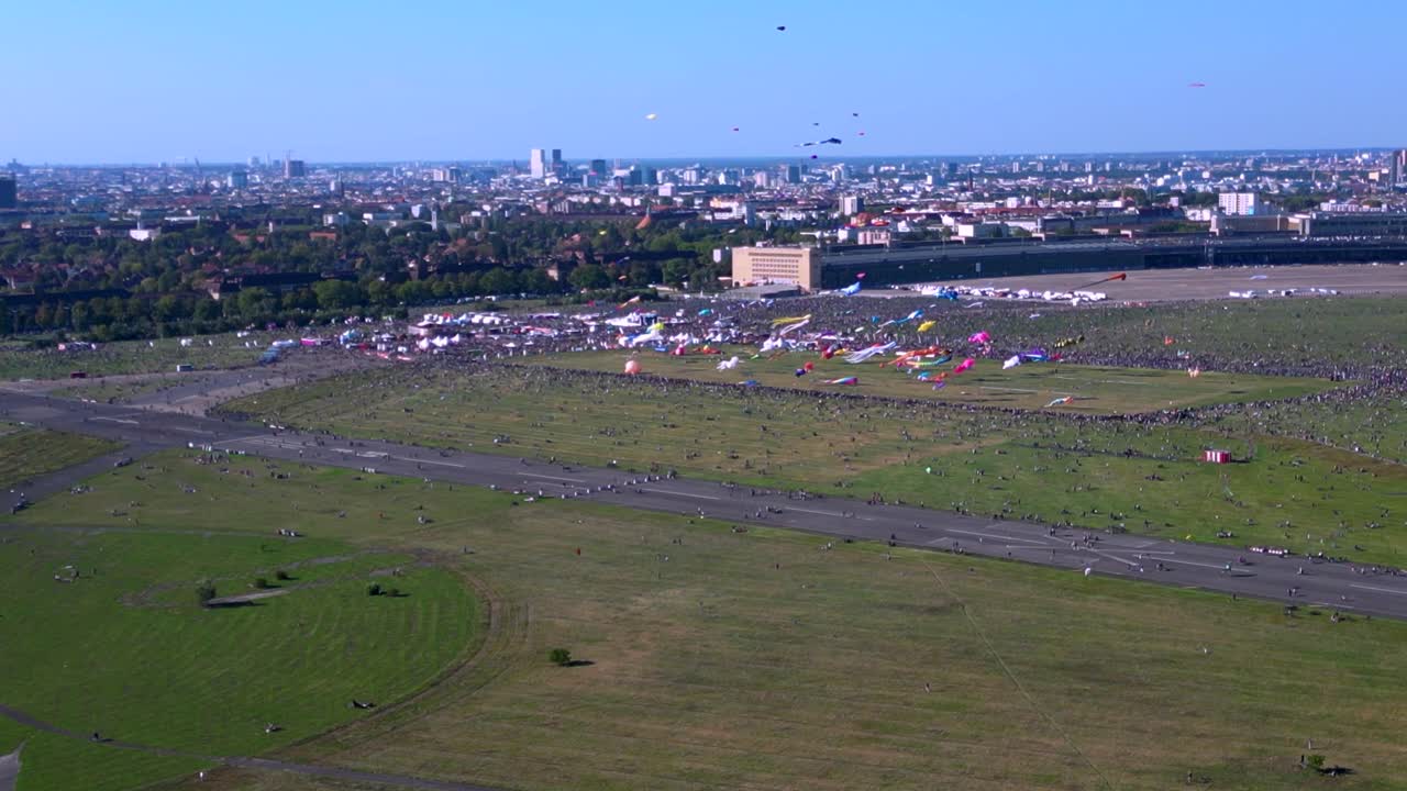 Large crowd of people gathering at the Tempelhofer Feld giant kite festival in Berlin, Germany. Majestic aerial view flight panorama overview drone