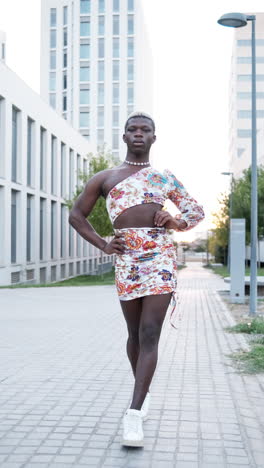man in one-shoulder floral dress on city street