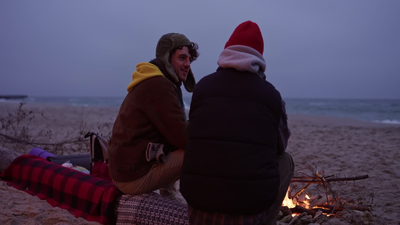 Couple Enjoying a Campfire on the Beach at Dusk