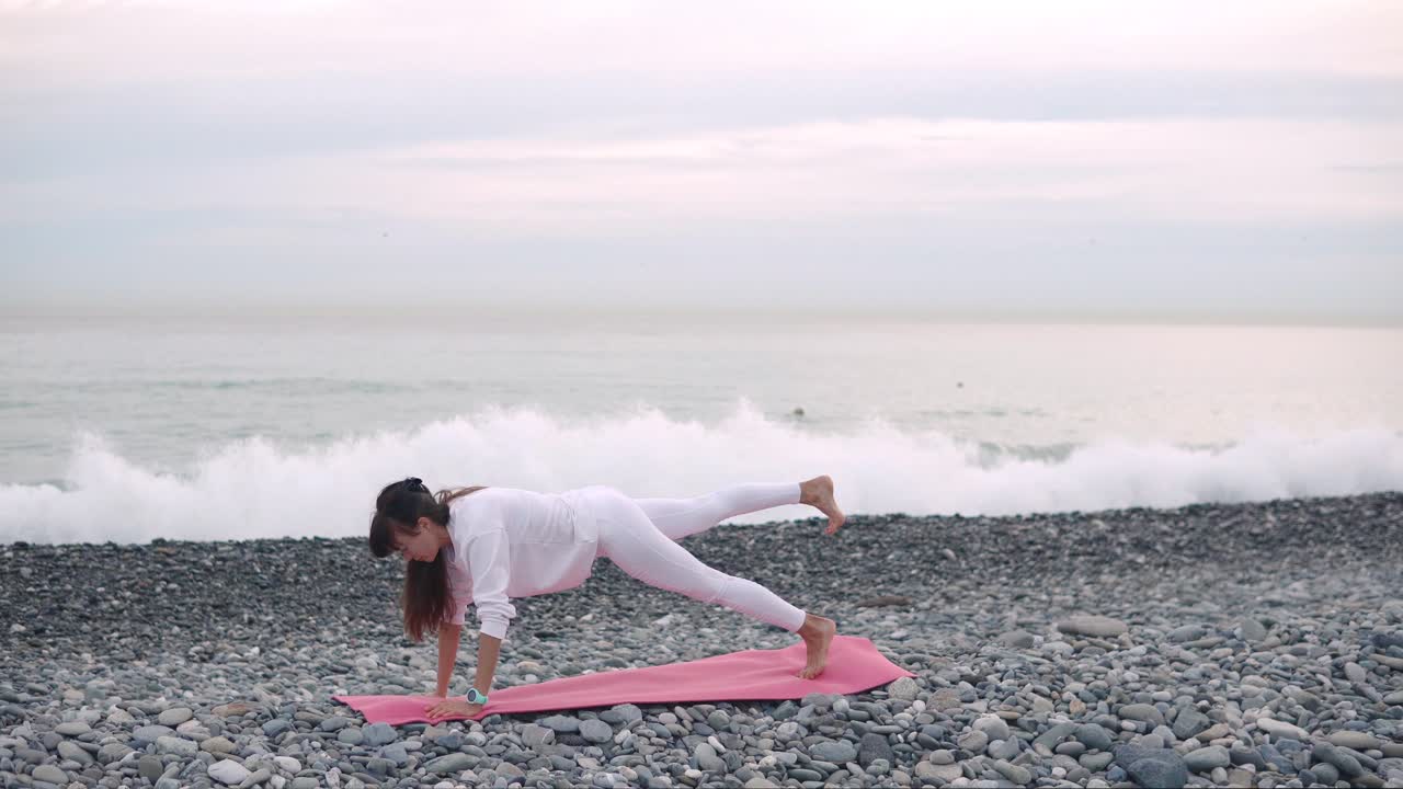 mujer practicando yoga en la playa