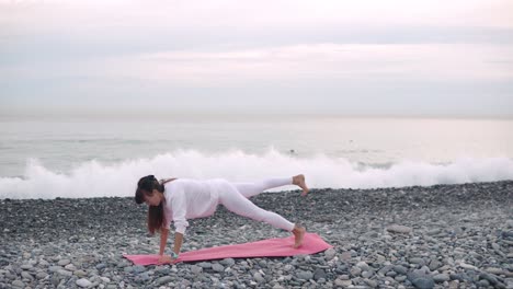 woman practicing yoga on a beach