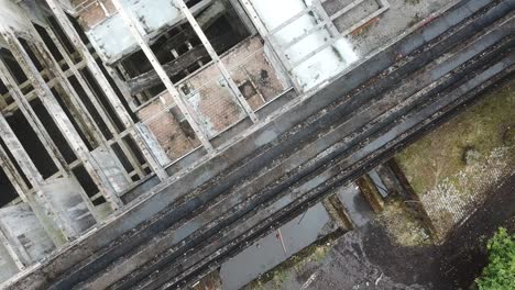 Birdseye-aerial-video-of-a-ruined-abandoned-building-showing-only-old-stone-and-beams