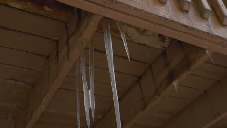 handheld shot of melting icicles hanging from a balcony