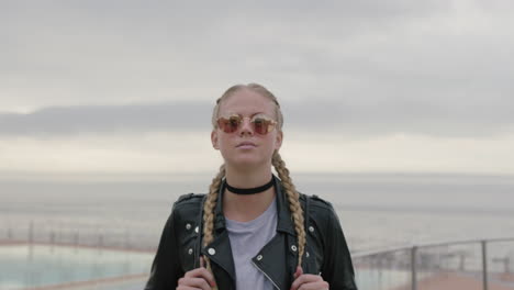 portrait of beautiful blonde woman wearing sunglasses and leather jacket waiting