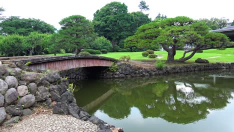 wooden bridge in the traditional japan garden with tree reflection on lake