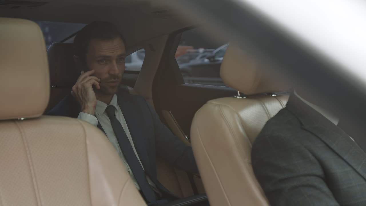 Successful Businessman in Car with Driver