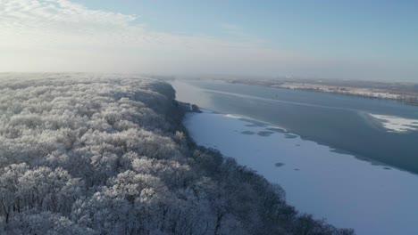 Im-Tiefflug-über-Frostige-Baumkronen,-Die-Die-Küstenstraße-Und-Den-Vereisten-Fluss-Enthüllen